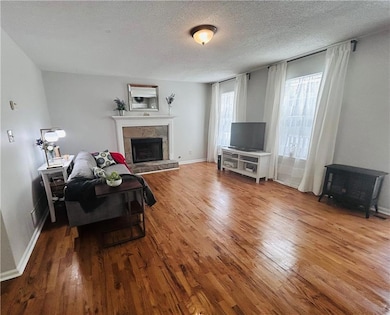 Living room featuring a fireplace, baseboards, woo