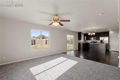 Unfurnished living room with a chandelier, a ceiling fan, dark carpet, and recessed lighting