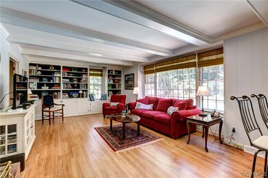 Bright and open family room with built in book cases, wood burning brick fireplace, wood floors and so much more.