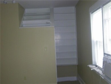 Another view of the living room with built in shel