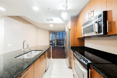 Kitchen with dark stone counters, light tile patte