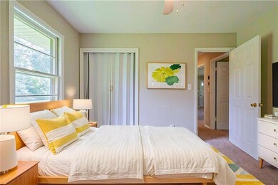 Bedroom with light carpet and a ceiling fan