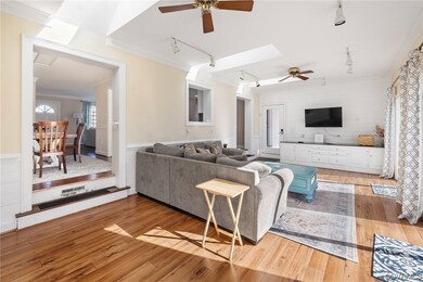 Living room with ceiling fan, ornamental molding,