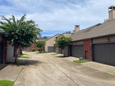 Spacious ally behind the townhome lined with crepe myrtles.