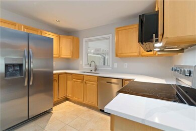 Kitchen featuring appliances with stainless steel finishes, light brown cabinets, light countertops, and light tile patterned flooring