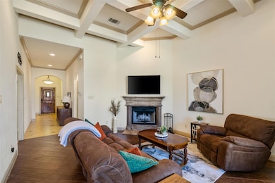 Living area with ceiling fan, crown molding, beam