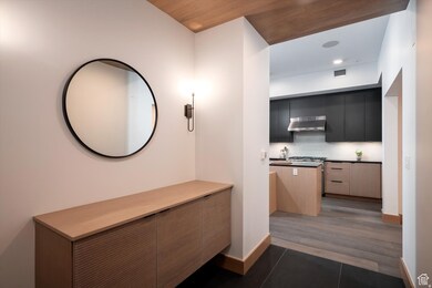 Corridor featuring dark tile patterned flooring and baseboards