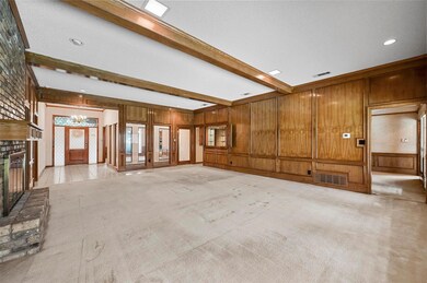 Unfurnished living room featuring beamed ceiling, 