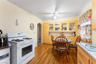 Kitchen with white gas range oven, light hardwood / wood-style floors, and ceiling fan