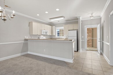 Kitchen featuring light carpet, kitchen peninsula,