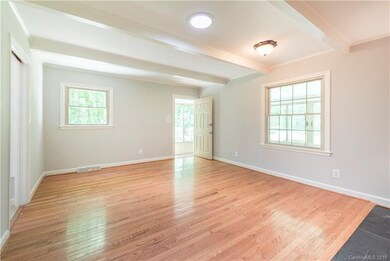 Family room/den offers gleaming wood floors and ac