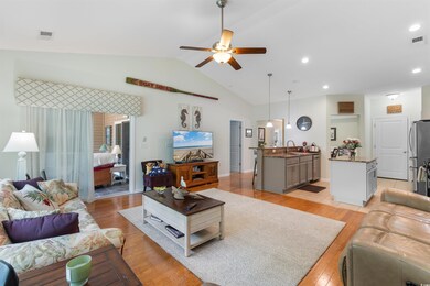 Living area featuring ceiling fan, lofted ceiling, light wood-style flooring, and recessed lighting