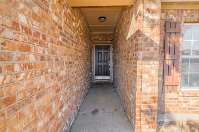 Entrance to property featuring brick siding