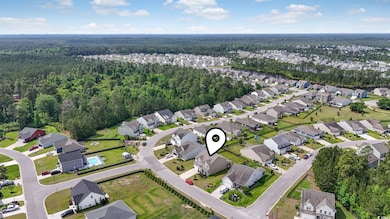 Aerial overview of property's location with a forest and nearby suburban area