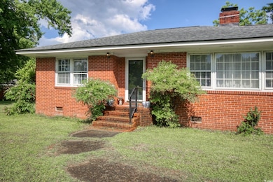 View of front of house featuring crawl space, brick siding, and a front lawn