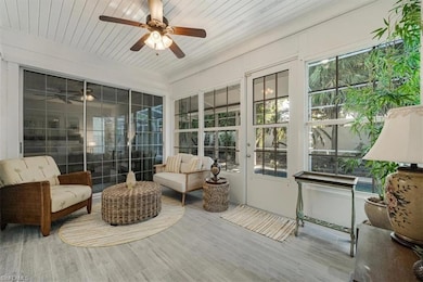Sunroom / solarium featuring a ceiling fan, plenty of natural light, and french doors
