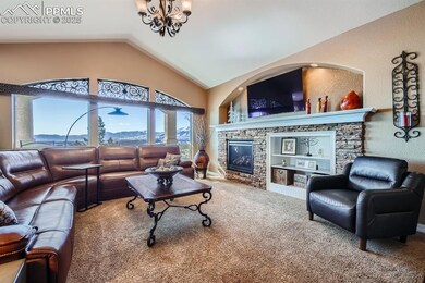 Living room with lofted ceiling, a mountain view, carpet floors, a notable chandelier, and a fireplace