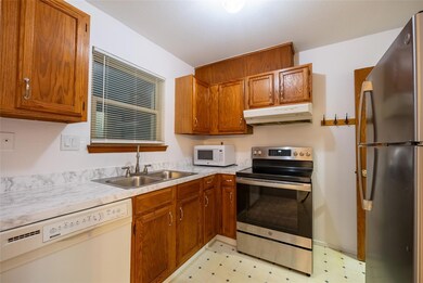 Kitchen featuring under cabinet range hood, stain