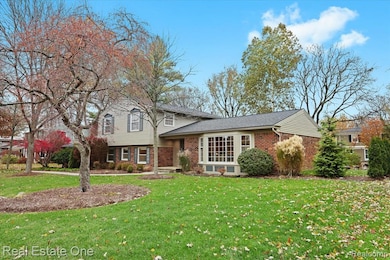 Split level home with brick siding and a front lawn