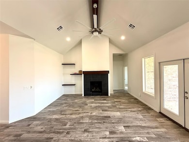 Unfurnished living room with ceiling fan, high vaulted ceiling, dark wood-style flooring, a tile fireplace, and recessed lighting