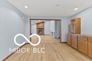interior space with brown cabinets, light wood-style flooring, recessed lighting, a fireplace, and baseboards