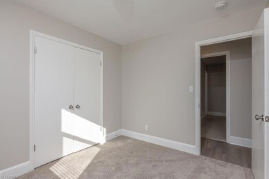 Bedroom 2: Features include new carpet flooring to help keep your feet warm on cool mornings, fresh new paint and a window for natural lighting with blinds for privacy. The double door closet is to the left side and the entry door is to the right side.
