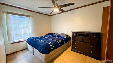 Bedroom with a ceiling fan, crown molding, and baseboards