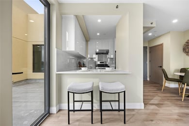 Kitchen with light countertops, a breakfast bar, gas range, and range hood