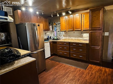 Kitchen with track lighting, sink, dark hardwood /