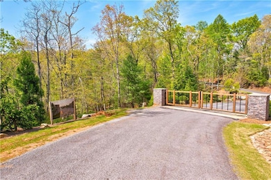View of gate featuring a forest view and fence