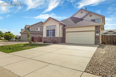 Traditional-style house featuring stone siding, an attached garage, concrete driveway, and a shingled roof