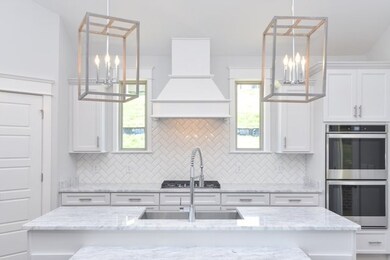 Luxury Kitchen with cabinet venthood and double ovens. This photo is not of actual home. For representation purposes only. 