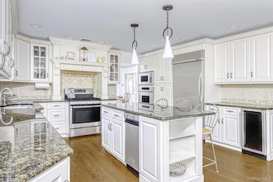 Kitchen featuring tasteful backsplash, open shelves, dark stone countertops, white cabinetry, and recessed lighting