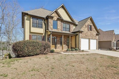 View of front of house with stone siding, driveway