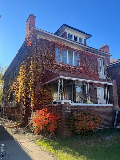 View of front of property with a chimney, brick siding, and a porch