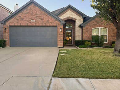 French country style house with brick siding, concrete driveway, a front lawn, and a garage