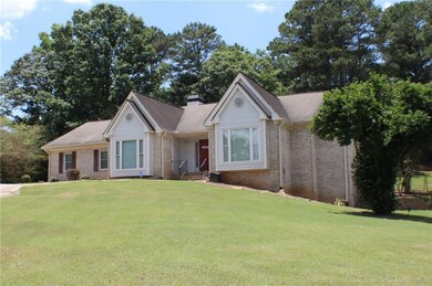 Ranch-style house featuring brick siding, a front yard, and a chimney