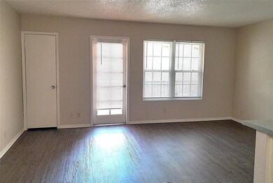 Empty room with baseboards, a textured ceiling, a