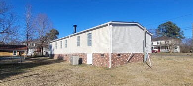 View of side of home featuring a yard, a trampolin