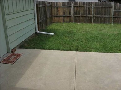 Large concrete patio area with access to garage.