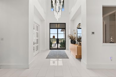 Entryway featuring baseboards, a notable chandeli