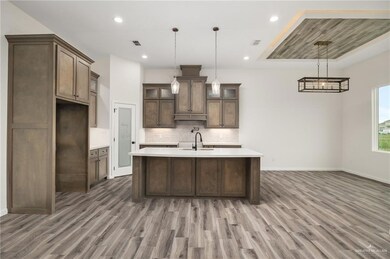 Kitchen featuring backsplash, dark hardwood / wood-style floors, and an island with sink