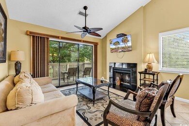 Living area featuring a ceiling fan, healthy amount of natural light, lofted ceiling, a fireplace, and baseboards