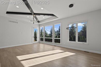 Unfurnished room featuring a chandelier, light wood-style floors, a raised ceiling, and recessed lighting