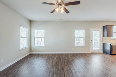 Unfurnished living room with baseboards, visible vents, wood finished floors, and a ceiling fan