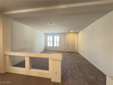 Spare room with visible vents, dark carpet, basebo