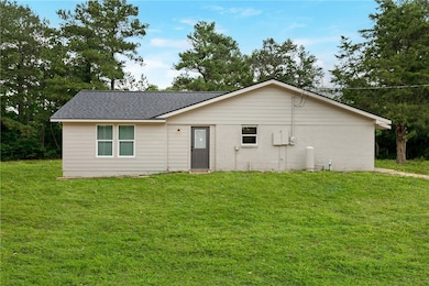 Side entry door of the home. Beautiful mature trees surround the home.