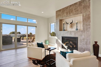 Living area with wood finished floors, a fireplace, recessed lighting, and baseboards