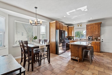 Kitchen featuring brown cabinetry, stainless steel appliances, a kitchen breakfast bar, a kitchen island, and recessed lighting