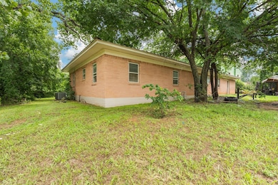 View of property exterior featuring a lawn and cen